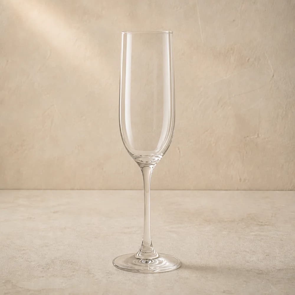 An empty clear champagne flute with a tall narrow bowl and slender stem.