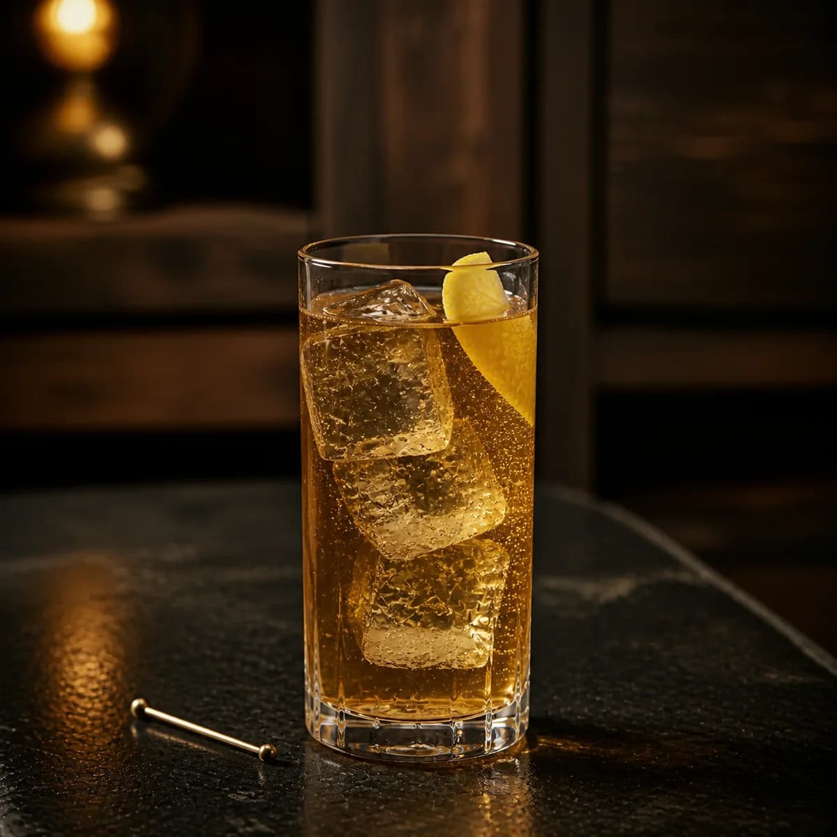 Horse’s Neck in a tall straight-sided highball glass styled in a neighborhood speakeasy with irregular dark-walnut shelves and worn black soapstone.