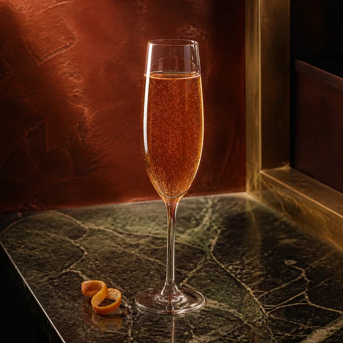Kir Royale in a slender champagne flute styled in a Milan aperitivo bar with oxblood hand-painted plaster, asymmetric aged brass and dark green marble.