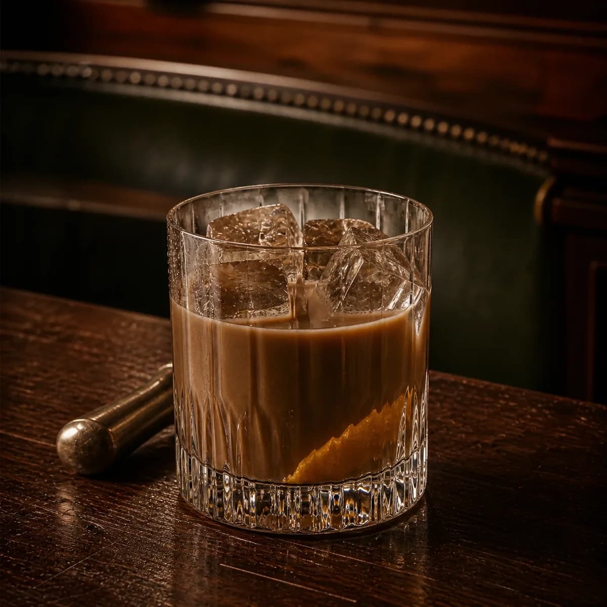 Mudslide in a heavy low rocks glass styled in an old railway club bar with bottle-green leather, mahogany and aged nickel.
