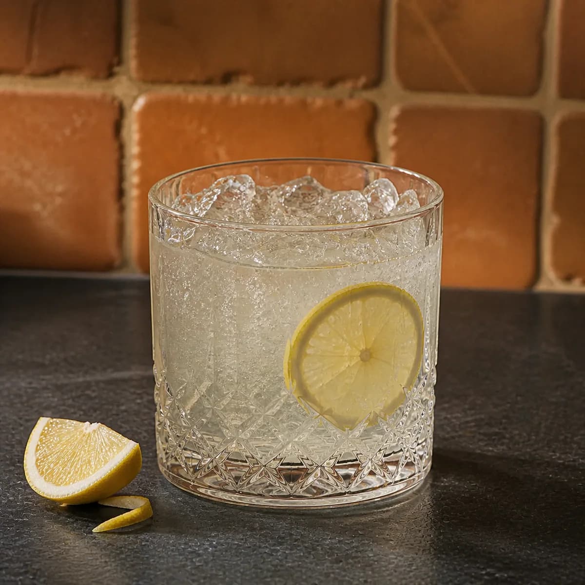 Tequila Fix in a heavy low rocks glass styled in a contemporary cantina with handmade terracotta zellige, imperfect grout and matte charcoal soapstone.
