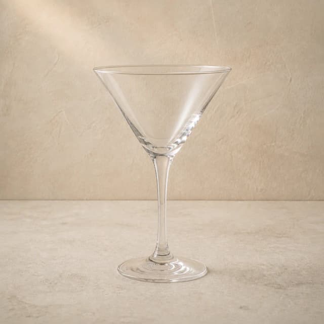 An empty clear martini glass with an angular V-shaped bowl and slender stem.